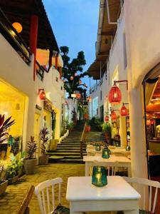 une allée avec des tables et des chaises dans un bâtiment dans l'établissement Suítes Modernas no Centro da Praia da Pipa, à Pipa