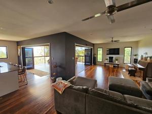 ein großes Wohnzimmer mit einem Sofa und einem Tisch in der Unterkunft Atherton Tablelands - great views, acreage & pet friendly in Tolga