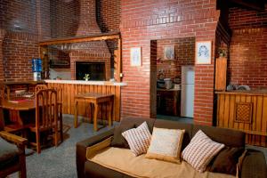a living room with a couch and a brick wall at Country house, friends, meetings, well connected in Luque