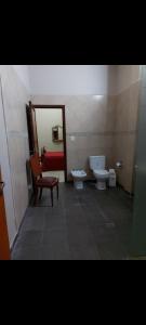a bathroom with two toilets and a chair and a mirror at Hermosa casa centrica in La Banda