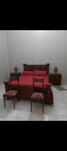 a bedroom with a red bed and two chairs at Hermosa casa centrica in La Banda