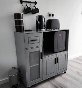 a kitchen cart with a microwave and a coffee maker at Payne’s Pad in Poole