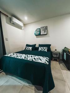 1 dormitorio con 1 cama con edredón blanco y negro en Five Moderno Depto. Ciudad de las Esculturas en Resistencia