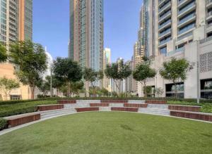 a park in the middle of a city with tall buildings at Burj Khalifa view - Modern 1BDR apartment in Dubai