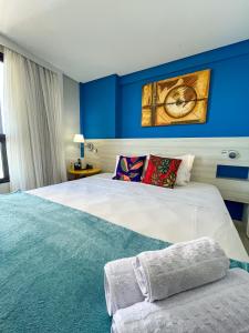 a bedroom with a large bed with blue walls at Ponta Negra Flats Confort ACCOMMODATIONS AMAQ 18 andar in Natal
