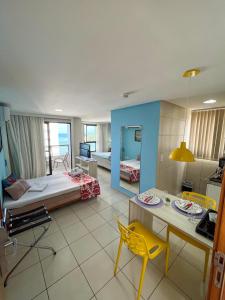 Ponta Negra Flats Confort ACCOMMODATIONS AMAQ 18 andar في ناتال: غرفة معيشة مع سرير وغرفة طعام