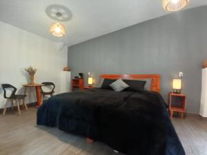 1 dormitorio con 1 cama negra grande y 2 lámparas en Piedra Negra Boutique Hotel en San Cristóbal de Las Casas