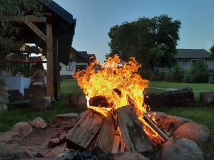a fire pit with flames in a yard at Willa Kumat in Brańsk
