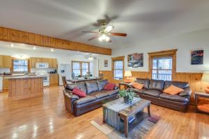 a living room with leather couches and a ceiling fan at Hiawassee Vacation Rental with Grill about 9 Mi to Lake! in Hiawassee