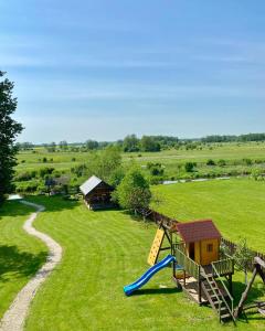 um parque infantil com um escorrega no meio de um campo em Willa Kumat em Brańsk
