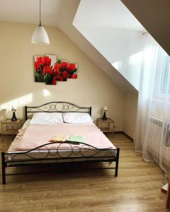 um quarto com uma cama com flores vermelhas na parede em Willa Kumat em Brańsk