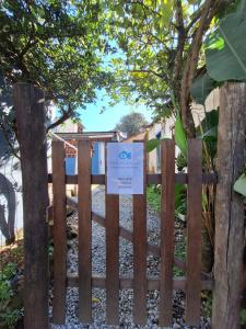 uma cerca de madeira com um sinal em Casa da Manjuba em Angra dos Reis