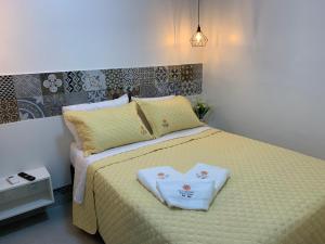 Un dormitorio con una cama con una toalla en forma de corazón. en FLAT ECO RESORT PRAIA DOS CARNEIROS en Tamandaré
