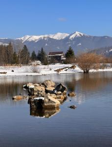 a body of water with rocks in the water with mountains at Serenity Colibița in Colibiţa