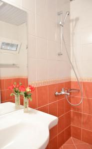 un bagno con lavandino e doccia con fiori in vaso di Vita Park Hotel & Aqua Park ad Albena