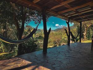 a hammock on a porch with a view of the mountains at Granja los Campesinos in Monteverde Costa Rica
