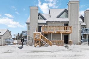 a large house with a deck in the snow at Luxury Studio Getaway at Blue Mountains 80114 in Blue Mountains