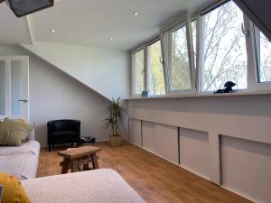 een woonkamer met een trap met ramen bij BB Sunshine in Schijndel