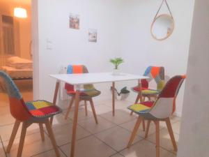 a table with four chairs and a white table and a table at Le Fjørd - Appartement confort, rez-de-chaussée, scandinave, parking gratuit in Bourges