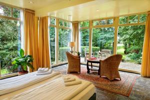 a bedroom with two beds and a table and chairs at Hotel Restaurant Oortjeshekken in Ooij