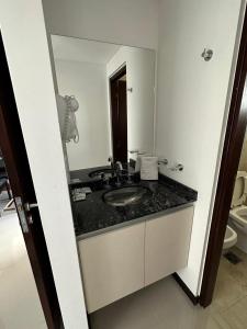 a bathroom with a sink and a mirror at Veneto Village Departamento 5min De Carlos Paz- Vista al lago in Villa Parque Siquiman
