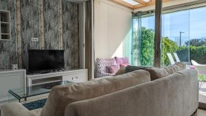 uma sala de estar com um sofá e uma televisão em PARADISE beachfront luxury villa em Villajoyosa