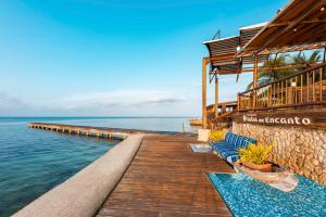 a resort with a wooden walkway over the water at Hotel Isla del Encanto in Baru