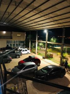 un groupe de voitures garées sur un parking la nuit dans l'établissement HOSPEDAJE LA NORMA, à Paso de los Libres