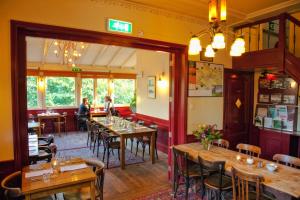 a restaurant with wooden tables and chairs in a room at Hotel Restaurant Oortjeshekken in Ooij