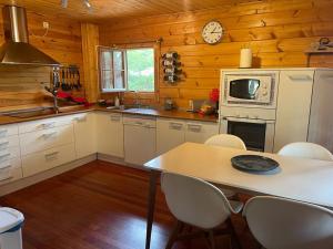 a kitchen with a table with chairs and a microwave at EL BOSQUE ENCANTADO in La Estación