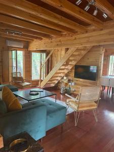 a living room with a blue couch and a tv at EL BOSQUE ENCANTADO in La Estación