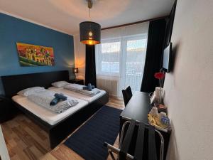 MariahofにあるJerà am Furtnerteich Hotel-Ristorante&Relaxのベッド2台とデスクが備わる客室です。