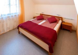 dastraunseehaus في تروكيرشن: غرفة نوم بسرير كبير ومخدات حمراء