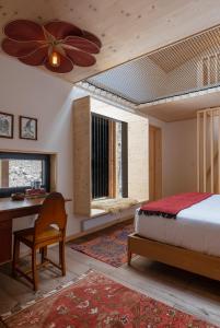 Eastwind Hotel Oliverea Valley في Big Indian: غرفة نوم مع سرير ومكتب ومروحة سقف