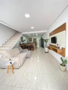 a living room with a couch and a staircase at Casa linda em Campo Grande rj in Rio de Janeiro