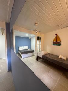 a bedroom with two beds and a sailboat on the wall at Pousada Bosque dos Papagaios in Búzios