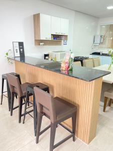 a kitchen with a counter with chairs around it at Casa linda em Campo Grande rj in Rio de Janeiro