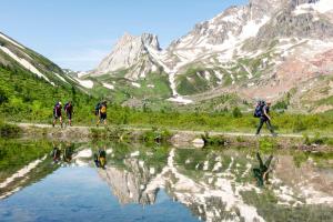 a group of people walking along a mountain lake at La Petite in Courmayeur