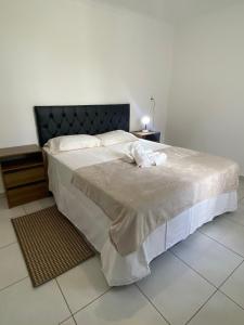 una camera con un grande letto con testiera nera di RCM Vilas - Casa Confortável 02 a Joinville