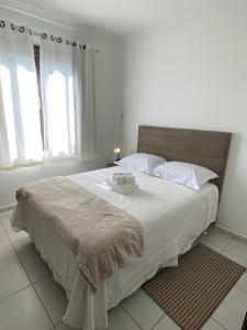 una camera da letto con un grande letto con lenzuola bianche di RCM Vilas - Casa Confortável 02 a Joinville