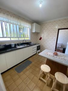 a kitchen with white cabinets and a table and chairs at RCM Vilas - Casa Confortável 02 in Joinville