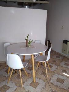 einem Tisch mit zwei Stühlen und einem Tisch mit einer Pflanze darauf in der Unterkunft Departamento Zapata 5ta Mendoza in Mendoza