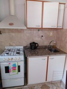 eine Küche mit einem weißen Herd und einer Spüle in der Unterkunft Departamento Zapata 5ta Mendoza in Mendoza