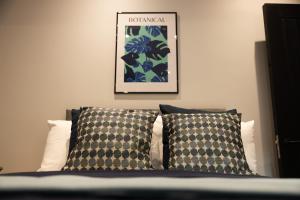 un letto con due cuscini e una foto sul muro di Harland House a Belfast