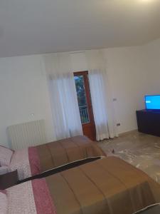 Paganica的住宿－B&B Paradiso，一间卧室配有两张床和电视。