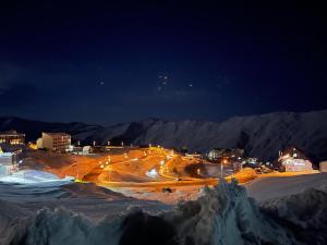 Eine Stadt leuchtete nachts im Schnee in der Unterkunft New Gudauri View in Gudauri