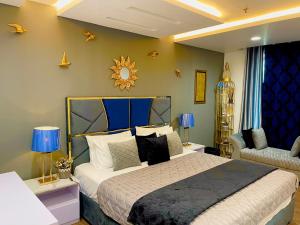 a bedroom with a large bed and a chair at 2BR Gold Crest Luxurious Residency Apartment BY AirHomes DHA Lahore in Lahore