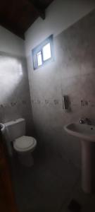 a bathroom with a toilet and a sink and a window at El Remanso del Casero in Gualeguay