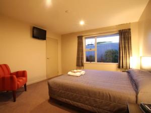 Un dormitorio con una cama grande y una ventana en 388 Tay Motel, en Invercargill