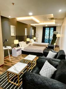 salon z 2 łóżkami i kanapą w obiekcie 2BR Gold Crest Luxurious Residency Apartment BY AirHomes DHA Lahore w mieście Lahaur